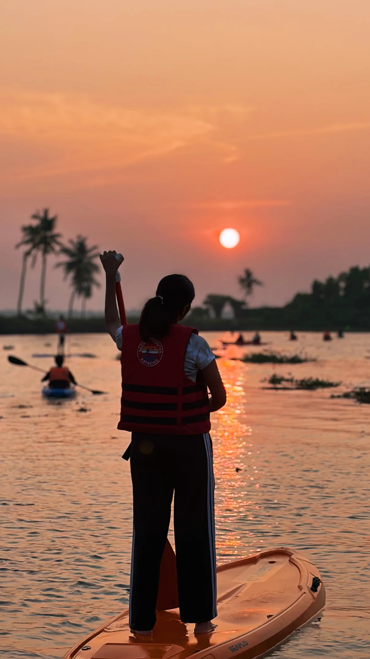 Kayak on a narrow village canal lined with palms